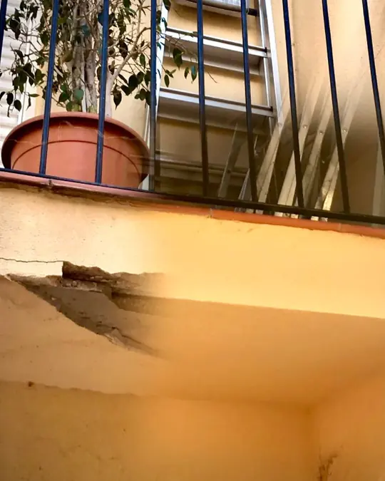 Rehabilitación de fachada: balcón con el hierro a la vista, en reparación
