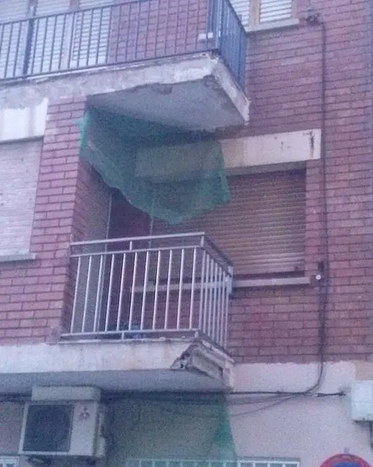 Los balcones del edificio, con la red de protección: Rehabilitación fachada Barcelona: balcón de una comunidad de Barcelona, antes de repararlo