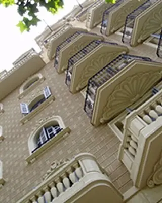 Rehabilitación de fachada: fachada con balcones y molduras, rehabilitada