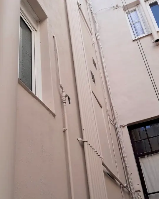 Rehabilitación fachada Barcelona: patio de luces reparado y pintado en Barcelona
