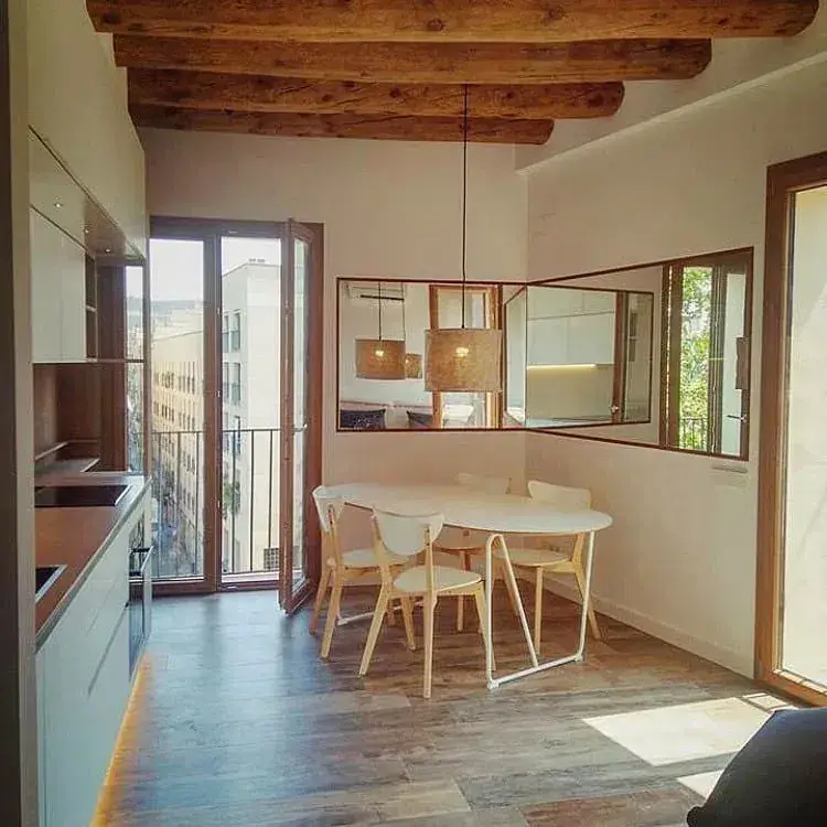 Salón con las vigas de madera recuperadas en un piso de El Raval de Barcelona