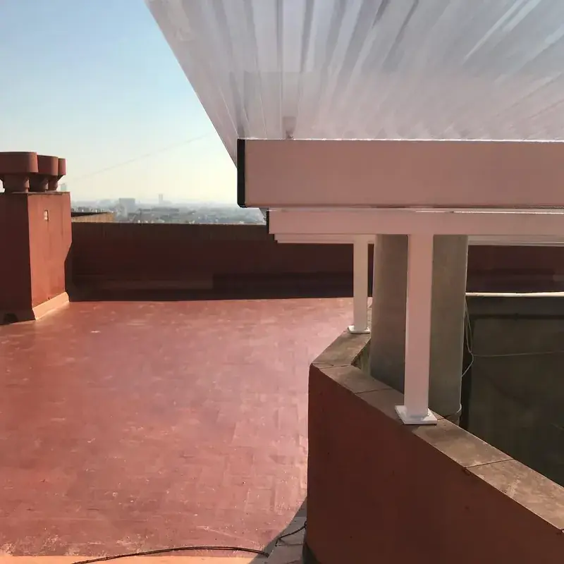 Terraza comunitaria impermeabilizada, con pérgola, en un edificio rehabilitado