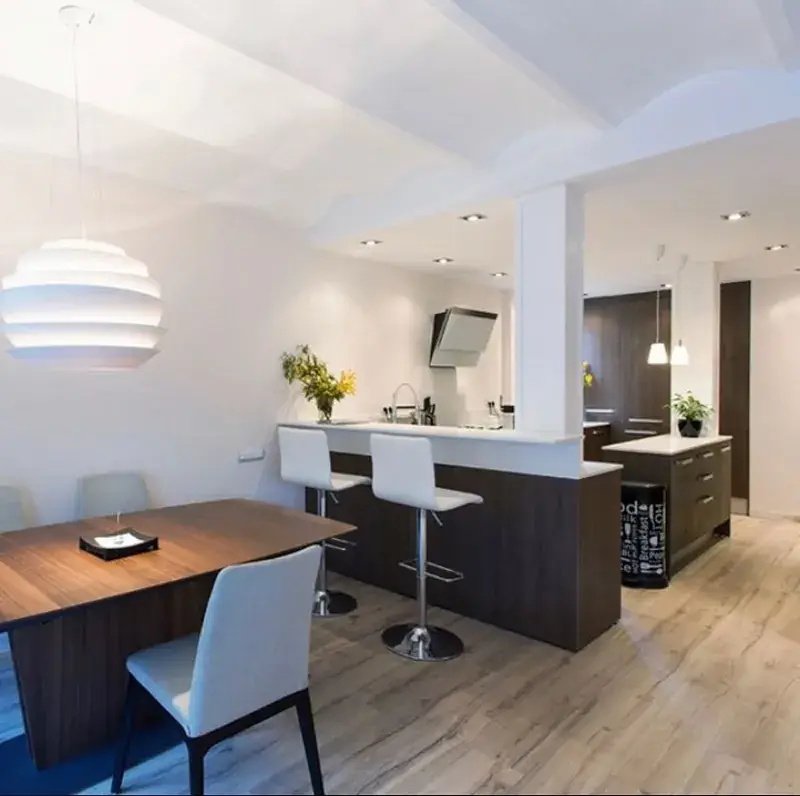 Comedor con cocina abierta de un piso reformado en Barcelona